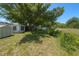Large backyard with lush green grass, storage shed and screened in lanai at 10031 Cherry Creek Ln, Port Richey, FL 34668