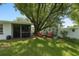 Lush backyard featuring mature trees and patio furniture, perfect for outdoor relaxation at 10031 Cherry Creek Ln, Port Richey, FL 34668