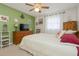 Comfortable bedroom with green accent wall, ceiling fan, and a large window with sheer curtains at 10031 Cherry Creek Ln, Port Richey, FL 34668