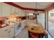 Bright kitchen featuring white cabinets, red accents, and modern appliances near the sliding door at 10031 Cherry Creek Ln, Port Richey, FL 34668