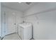 A tidy laundry room featuring a white washer and dryer set and a wire shelf at 10245 Shady Preserve Dr, Riverview, FL 33578