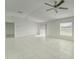 Bright, open living room with tile flooring, ceiling fan, and sliding glass door at 10245 Shady Preserve Dr, Riverview, FL 33578