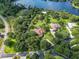 An aerial view of two landscaped homes with tile roofs nestled in a lush green neighborhood next to a lake at 10504 Echo Lake Dr, Odessa, FL 33556