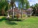 Beautiful backyard featuring a screened-in lanai, mature landscaping, and vibrant green lawn at 10504 Echo Lake Dr, Odessa, FL 33556