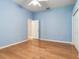 Bright bedroom with hardwood floors, light blue walls, ceiling fan and a door to the side at 10504 Echo Lake Dr, Odessa, FL 33556