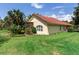Side view of home with a red tile roof, mature landscaping, and a screened-in porch at 10504 Echo Lake Dr, Odessa, FL 33556