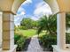 View of the landscaped front yard and brick walkway from the arched entrance at 10504 Echo Lake Dr, Odessa, FL 33556