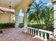 Covered front porch with brick flooring, decorative columns, and manicured landscaping at 10504 Echo Lake Dr, Odessa, FL 33556