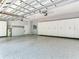 Spacious garage with epoxy flooring, custom cabinets, and ample room for multiple vehicles and storage at 10504 Echo Lake Dr, Odessa, FL 33556