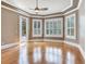 Main bedroom featuring hardwood floors, tray ceiling, plantation shutters, and outdoor access at 10504 Echo Lake Dr, Odessa, FL 33556