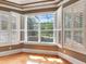 Bedroom with hardwood floors, plantation shutters, and view of screened pool and landscaping at 10504 Echo Lake Dr, Odessa, FL 33556