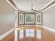 Main bedroom featuring hardwood floors, tray ceiling, and windows with plantation shutters at 10504 Echo Lake Dr, Odessa, FL 33556