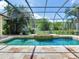 Sparkling pool and spa with screened enclosure, offering a serene outdoor retreat with lush greenery at 10504 Echo Lake Dr, Odessa, FL 33556