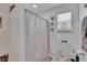 Bright bathroom featuring a shower with patterned curtain and decorative window accents at 10907 Golden Acorn Ave, Tampa, FL 33610