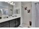 Bathroom with double sink vanity, large mirrors and decorative art, offers style and function at 10907 Golden Acorn Ave, Tampa, FL 33610