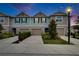 Charming townhome featuring a front-entry garage, landscaped yard, and a well-manicured lawn under the evening sky at 10907 Golden Acorn Ave, Tampa, FL 33610