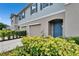 Close up of a charming townhome featuring a front-entry garage, and a well-manicured lawn at 10907 Golden Acorn Ave, Tampa, FL 33610