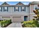 Charming townhome featuring a front-entry garage, stylish blue shutters, and a welcoming front door at 10907 Golden Acorn Ave, Tampa, FL 33610