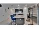 Well-lit kitchen featuring granite island, black cabinets, stainless steel appliances, and tiled flooring at 10907 Golden Acorn Ave, Tampa, FL 33610