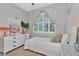 Cozy bedroom with natural light and modern decor featuring a large window with curtains at 11510 Quiet Forest Dr, Tampa, FL 33635