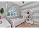 Bright bedroom showcasing a large window with charming curtains and a stylish accent wall at 11510 Quiet Forest Dr, Tampa, FL 33635
