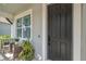 Welcoming front entrance with a black front door, outdoor seating, and neat landscaping at 11510 Quiet Forest Dr, Tampa, FL 33635