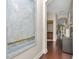Bright hallway with dark wood floors, decorative art and arched doorways at 11510 Quiet Forest Dr, Tampa, FL 33635
