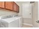 Efficient laundry room features upper cabinets for storage, washer, and dryer, maximizing functionality at 11510 Quiet Forest Dr, Tampa, FL 33635