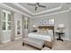 Serene main bedroom showcasing tray ceilings, custom window shutters, and elegant furnishings at 11510 Quiet Forest Dr, Tampa, FL 33635