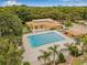 Aerial view of large community pool surrounded by trees and lounge chairs at 11816 Raintree Lake Ln # B, Tampa, FL 33617