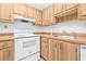 Efficient kitchen features wood cabinetry, white appliances, and tile flooring at 11816 Raintree Lake Ln # B, Tampa, FL 33617