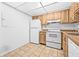 Efficient kitchen features wood cabinetry, white appliances, and tile flooring at 11816 Raintree Lake Ln # B, Tampa, FL 33617