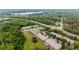 Aerial view of a residential neighborhood surrounded by lush greenery and a serene lake in the background at 11839 Castine St, New Port Richey, FL 34654