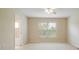 Beige-walled bedroom with a view to the outdoors, neutral carpet, and access to a bathroom at 11839 Castine St, New Port Richey, FL 34654