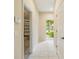 Hallway with views to the garage and outdoors, featuring tiled floors and neutral walls at 11839 Castine St, New Port Richey, FL 34654