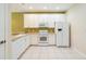 Bright kitchen featuring white appliances and cabinetry, tile floor, and a neutral countertop at 11839 Castine St, New Port Richey, FL 34654
