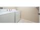 Laundry room with a white washer and dryer, neutral walls, and tiled floors at 11839 Castine St, New Port Richey, FL 34654