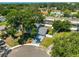 An aerial view shows a charming blue two-story home with a lush yard, a private pool and a white fence at 12468 Empire Dr, Seminole, FL 33772
