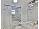 Bathroom featuring a white bathtub, tiled walls, niche, rainfall shower head, and modern lighting at 12468 Empire Dr, Seminole, FL 33772