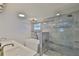 Modern bathroom featuring dual sinks, a soaking tub and glass shower at 12468 Empire Dr, Seminole, FL 33772