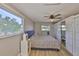 Bright bedroom with wood floors, ceiling fan, and sliding door closet with mirrors at 12468 Empire Dr, Seminole, FL 33772