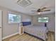 Bedroom features wood floors, two windows and an AC unit, with a double bed at 12468 Empire Dr, Seminole, FL 33772