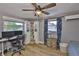 Bedroom with wood floors and a ceiling fan shows a white bookshelf and window at 12468 Empire Dr, Seminole, FL 33772