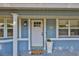 Charming front door with blue siding, white trim, pillar, and a potted plant at 12468 Empire Dr, Seminole, FL 33772