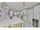Bright, modern kitchen with white cabinets, stainless steel appliances, large center island with chairs, and a wine fridge at 12468 Empire Dr, Seminole, FL 33772
