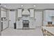 Bright kitchen featuring stainless steel appliances, stone countertops, and white cabinets at 12468 Empire Dr, Seminole, FL 33772