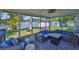 Relax on the screened-in patio furnished with comfortable wicker seating and a view of the fenced backyard at 12468 Empire Dr, Seminole, FL 33772