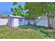 A well-maintained shed features a door and one window, and sits in a yard surrounded by a fence at 12468 Empire Dr, Seminole, FL 33772