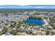 High aerial view of homes bordering a lake surrounded by trees and a verdant landscape under a clear sky at 12803 126Th Ter, Largo, FL 33774