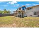 The backyard features ample green space, the home's exterior and a covered patio at 12803 126Th Ter, Largo, FL 33774